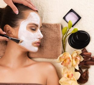 Woman having a facial cosmetic mask at spa salon.